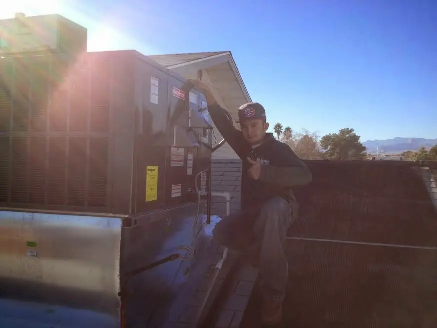 HVAC technician performing AC Tune-Up on a rooftop unit in Fellsmere