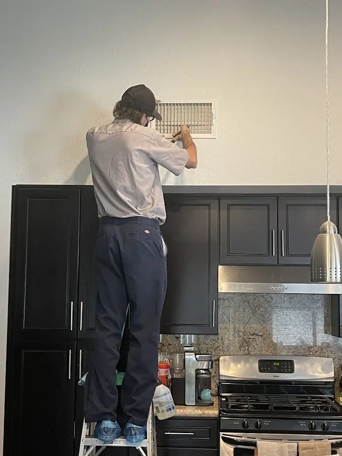 Technician inspecting an air vent during HVAC service in Fellsmere